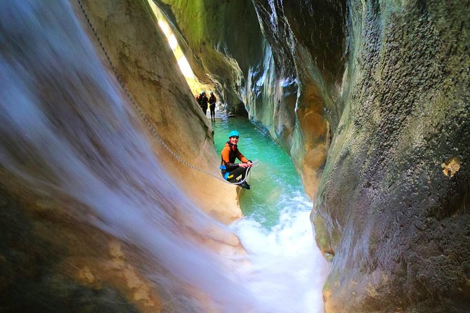 Adventurer canyoning through Skurda Canyon near Kotor, Montenegro with water rushing through narrow rock walls
