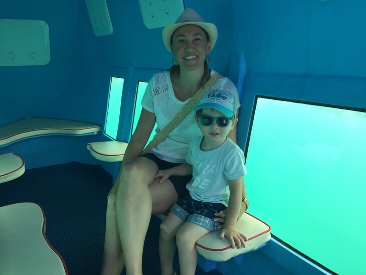 Smiling woman and child inside Kotor’s semi-submarine boat with underwater viewing windows