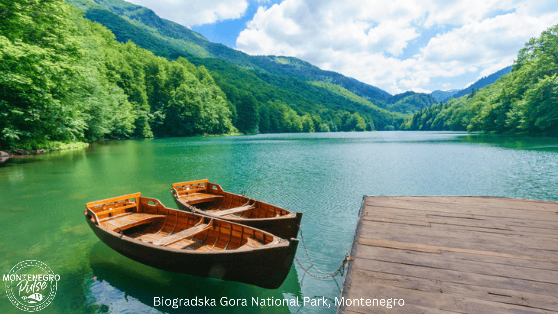 wo wooden boats docked at a serene lake surrounded by lush forests in Biogradska Gora National Park, Montenegro.