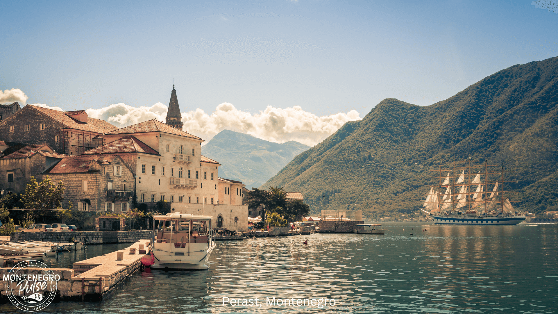 Historic buildings and narrow streets of Perast, Montenegro, along the Bay of Kotor with mountains in the background.
