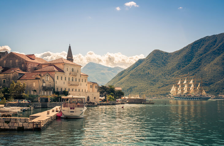Perast in Montenegro with sailboat passing Perast in Montenegro with sailboat passing