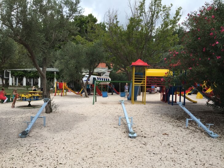 Family-Friendly Playground in Sveti Stefan, Montenegro Colorful children's playground with slides and seesaws surrounded by greenery at Sveti Stefan, Montenegro.